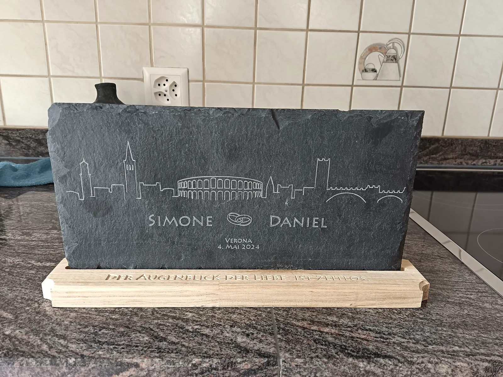 Schieferplatte mit gravierter Skyline von Verona, Namen und Ringen, auf einem Holzsockel